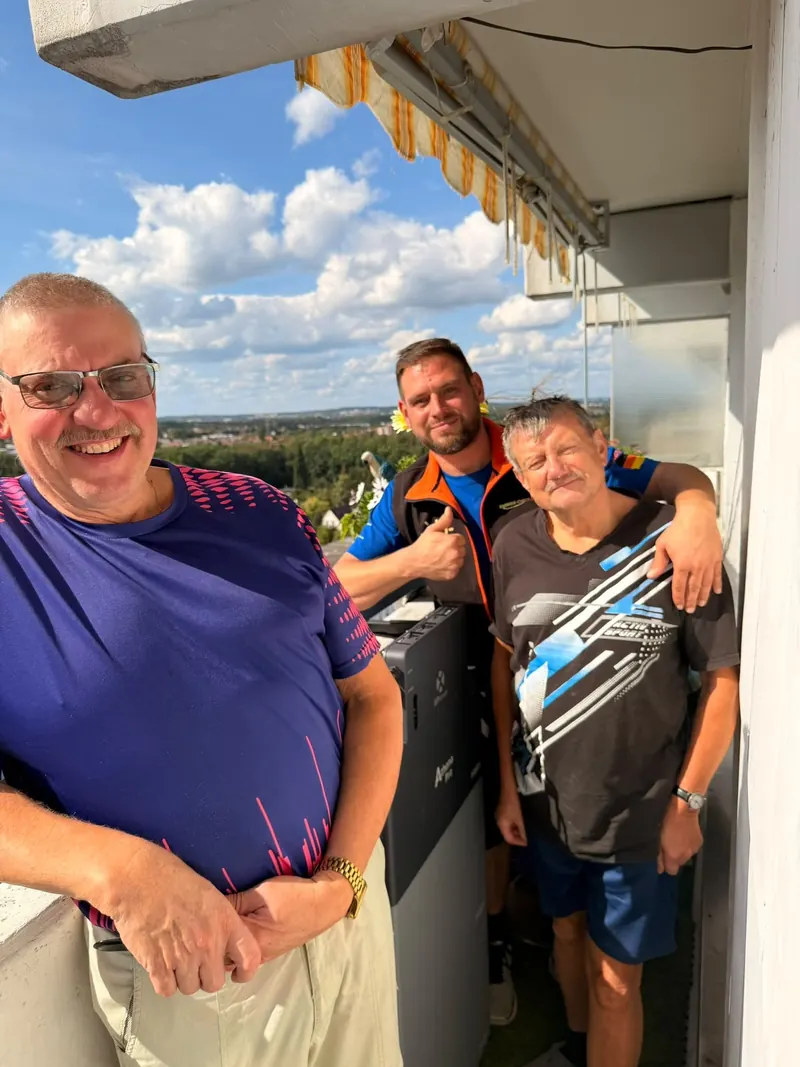 Familie Stolpmann & Egle mit EcoHome-Team und Batteriespeicher auf dem Balkon